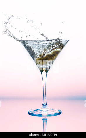 Una spruzzata di martini in un bicchiere da cocktail con olive. Foto Stock