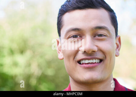 Outdoor testa e spalle Ritratto di sorridente Giovane Uomo Foto Stock