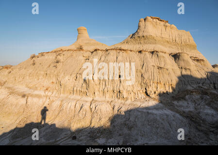 Escursionista in ombre di formazioni rocciose e hoodoos nel Parco Provinciale dei Dinosauri, Sito Patrimonio Mondiale dell'UNESCO, Alberta Badlands, Canada Foto Stock