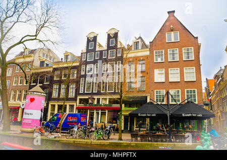 AMSTERDAM, PAESI BASSI, Aprile 23 2018: veduta esterna di alcuni edifici in riverside dei canali di Amsterdam è la capitale e la città più popolosa dei Paesi Bassi Foto Stock