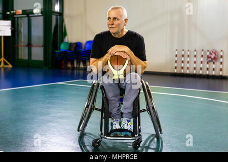 Sport disabili uomini relax durante la riproduzione indoor basketball presso un campo da pallacanestro Foto Stock