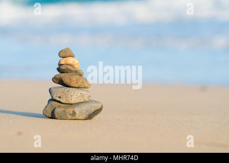 La piramide di pietre su di una spiaggia di sabbia sul mare Foto Stock