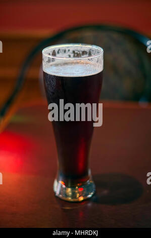 La pinta di ghiaccio freddo la birra nel bicchiere alto della taverna Foto Stock