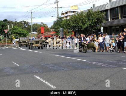 Folle allegria veterano army men marzo nel vintage veicoli militari in Coffs Harbour Anzac Day Parade in Australia Foto Stock