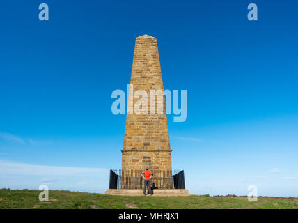 Easby Moor, North York Moors National Park North Yorkshire, Inghilterra, Regno Unito. Il 3 maggio, 2018. Meteo: Glorioso Sole nel North Yorkshire. Un walker sta sotto il capitano Cook monumento su Easby Moor, su cui si affaccia la fanciullezza villaggio di James Cook, grande Ayton. Il 2018 segna il 250 anniversario della Captain Cook il primo viaggio del Pacifico, con gli eventi programmati a livello nazionale per commemorare l'evento. Credito: ALAN DAWSON/Alamy Live News Foto Stock