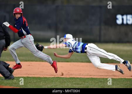 Primo baseman rendendo un diving tag su un baserunner che era stata caugnt tra la prima e la seconda base in un fatiscente giocare. Stati Uniti d'America. Foto Stock