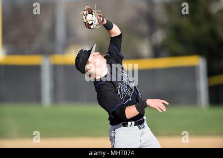 Terzo baseman combattendo contro il vento come egli si ritiene che le catture di un pop up sul infield. Stati Uniti d'America. Foto Stock