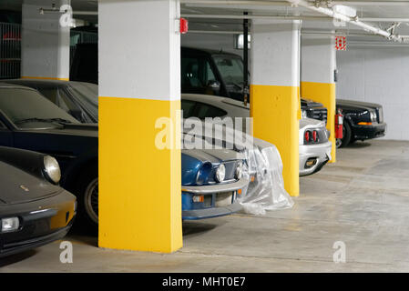Automobili di lusso costosi in un parcheggio sotterraneo a Montreal in Quebec. Essi sono coperti di polvere in quanto essi non sono stati utilizzati in anni. Foto Stock