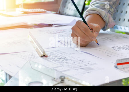 Concetto di architetti.Architetti workplace, progetto architettonico, blueprint, righello.engineer tenete la penna rivolta agli architetti di apparecchiature sulla scrivania con una b Foto Stock