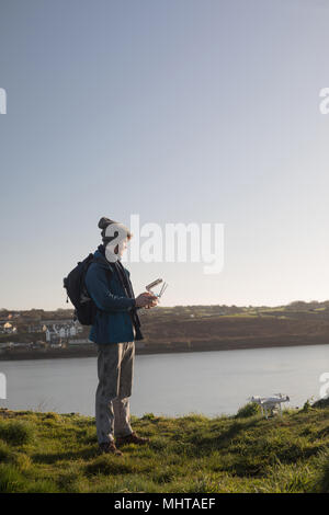 Escursionista maschio drone operativo vicino al lago Foto Stock