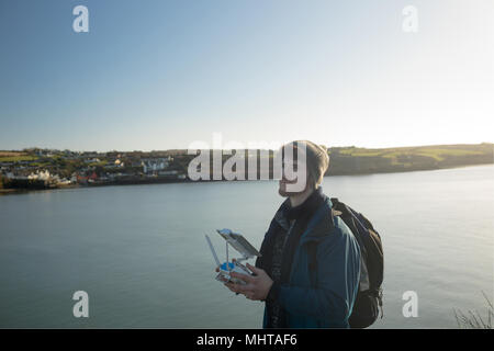 Escursionista maschio drone operativo vicino al lago Foto Stock