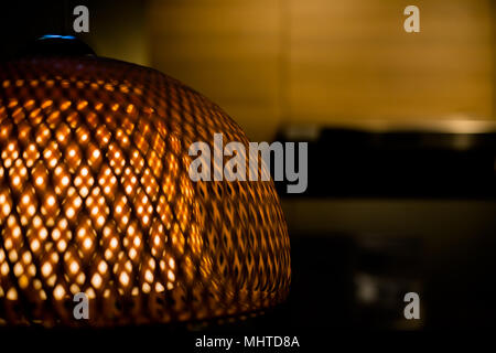 Close Up di lusso Bamboo lampada con luce gialla all'interno.Openwork paralume in vimini.old fashion lampada. Spazio di copia Foto Stock