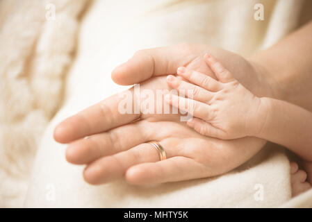 Bambino neonato mano. Primo piano della mano del bambino nelle mani dei genitori. La famiglia e la maternità e nascita del concetto. Foto Stock