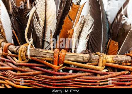 Colorate piume di uccelli in un busket di vimini. Medieval accessori decorativi. Bianco, grigio, marrone e arancione Foto Stock