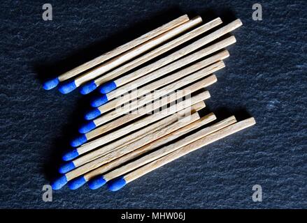 Raccolta di testa blu corrisponde a cui in fuori formando una forma della lettera Z su un nero grigio ardesia sfondo. Foto Stock