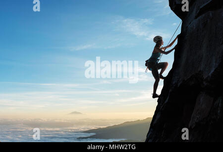 Giovane donna sulla scogliera arrampicata Foto Stock