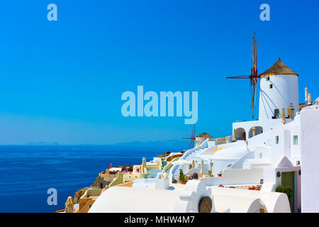 Villaggio di Oia con bianco tradizionale di poche case e mulini a vento in Santorini Island, Grecia Foto Stock