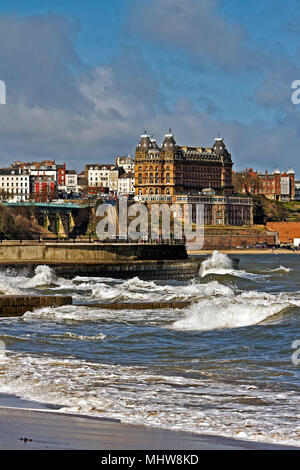 Il Grand Hotel si affaccia su di un alta marea onde di spinta contro il mare difese in Scarborough della South Bay. Foto Stock