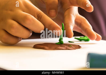 Bambini che giocano con la plastilina, modellazione tree. Sviluppo di fantasia e creatività. Foto Stock