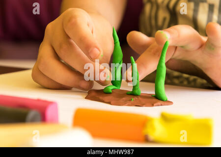 Bambini che giocano con la plastilina, modellazione tree. Sviluppo di fantasia e creatività. Foto Stock