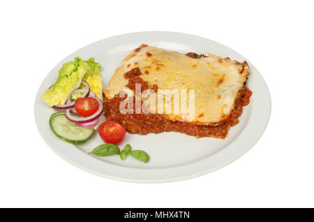 Lasagna di carne di manzo e insalata su una piastra isolata contro bianco Foto Stock