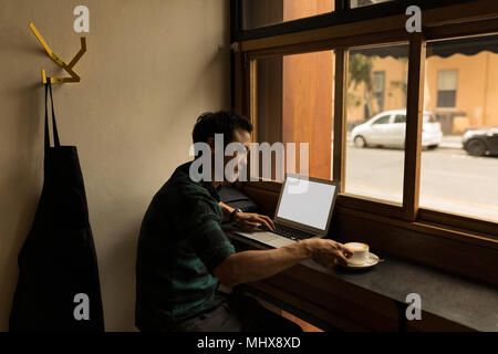 Uomo d affari con computer portatile mentre un caffè Foto Stock