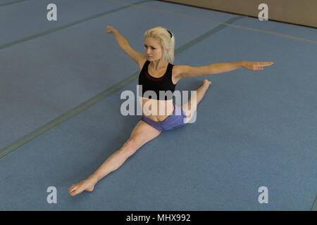 Sportive di eseguire esercizi di allungamento Foto Stock