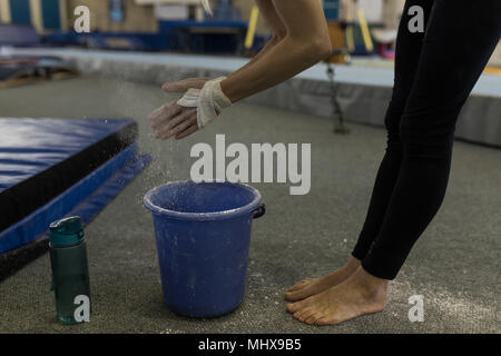 Sportive spolvero le mani con polvere di gesso Foto Stock
