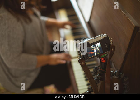 Bellissima femmina vlogger suonando piano Foto Stock
