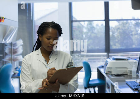 Donna scienziato iscritto negli appunti Foto Stock