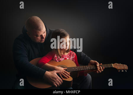 Padre figlia di insegnare a suonare la chitarra Foto Stock