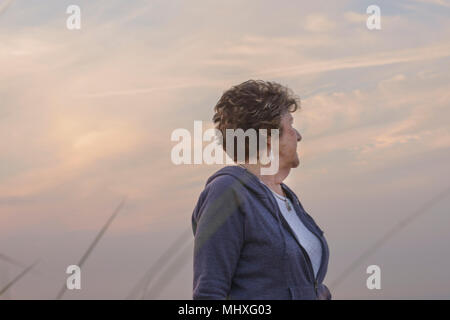 Donna con la faccia rivolta in allontanamento, sky in background Foto Stock