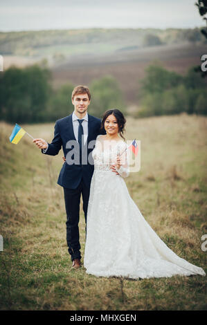 Lo sposo e la sposa tenendo le bandiere di Ucraina e Taiwan Foto Stock