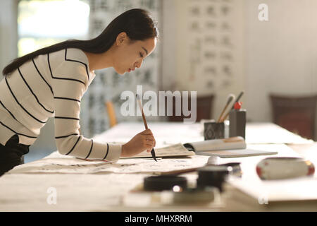 Le giovani donne di imparare la calligrafia Foto Stock