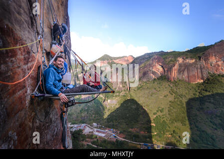 Ritratto di due arrampicatori su portaledge, la calcinazione, nella provincia dello Yunnan in Cina Foto Stock