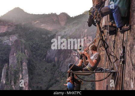 Due arrampicatori udienza del portaledge, guardando a vista, la calcinazione, nella provincia dello Yunnan in Cina Foto Stock