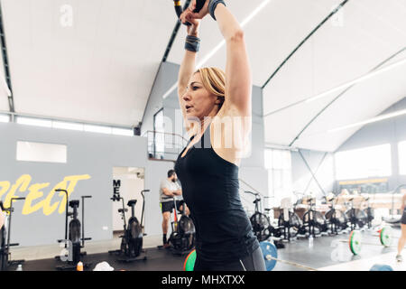 La donna il sollevamento pesi con bollitore campana in palestra Foto Stock