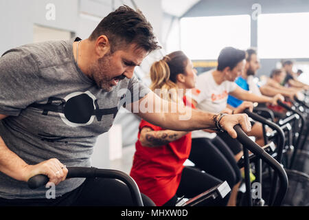 La gente in palestra con cyclette Foto Stock