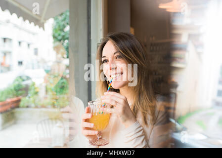 Donna con drink dalla finestra nel ristorante Foto Stock