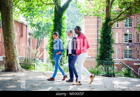 Tre uomini maturi a piedi in strada Foto Stock