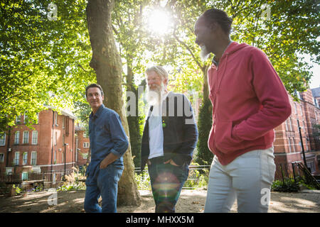 Tre uomini maturi a piedi in strada Foto Stock