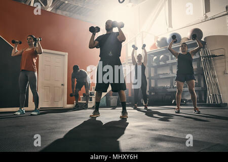 Uomo con manubri in palestra Foto Stock