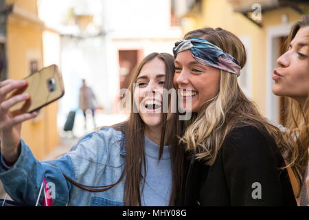 Amici prendendo selfie in strada Foto Stock