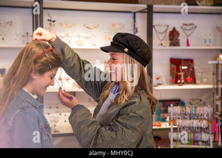 Due amiche, shopping, cercando su collana Foto Stock