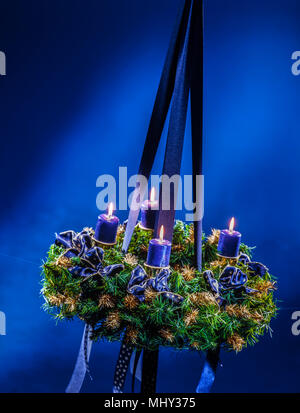 Corona di avvento con candele lucente e piena di atmosfera Foto Stock