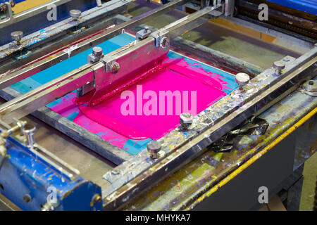 La serigrafia inchiostro stampante macchina rosa colore magenta nella fabbrica di stampa Foto Stock