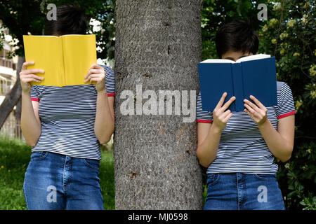 Gemelli legge libri nel parco - doppio effetto Foto Stock