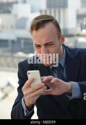 Imprenditore emotivamente utilizza lo smartphone Foto Stock