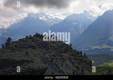 Piccolo coperchio di cairns una roccia su un altopiano percorso da Männlichen a Kleine Scheidegg, Oberland bernese, Svizzera Foto Stock