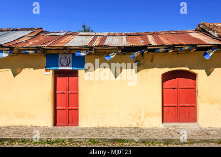 Antigua Guatemala - Ottobre 5, 2014: Vecchia casa dipinta adornata con bandiere Guatemalteca in città coloniale & UNESCO World Heritage Site di Antigua. Foto Stock